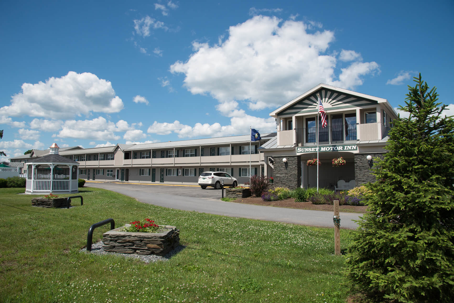 The Inn’s front view with Sunset design on building in green and tan colors.