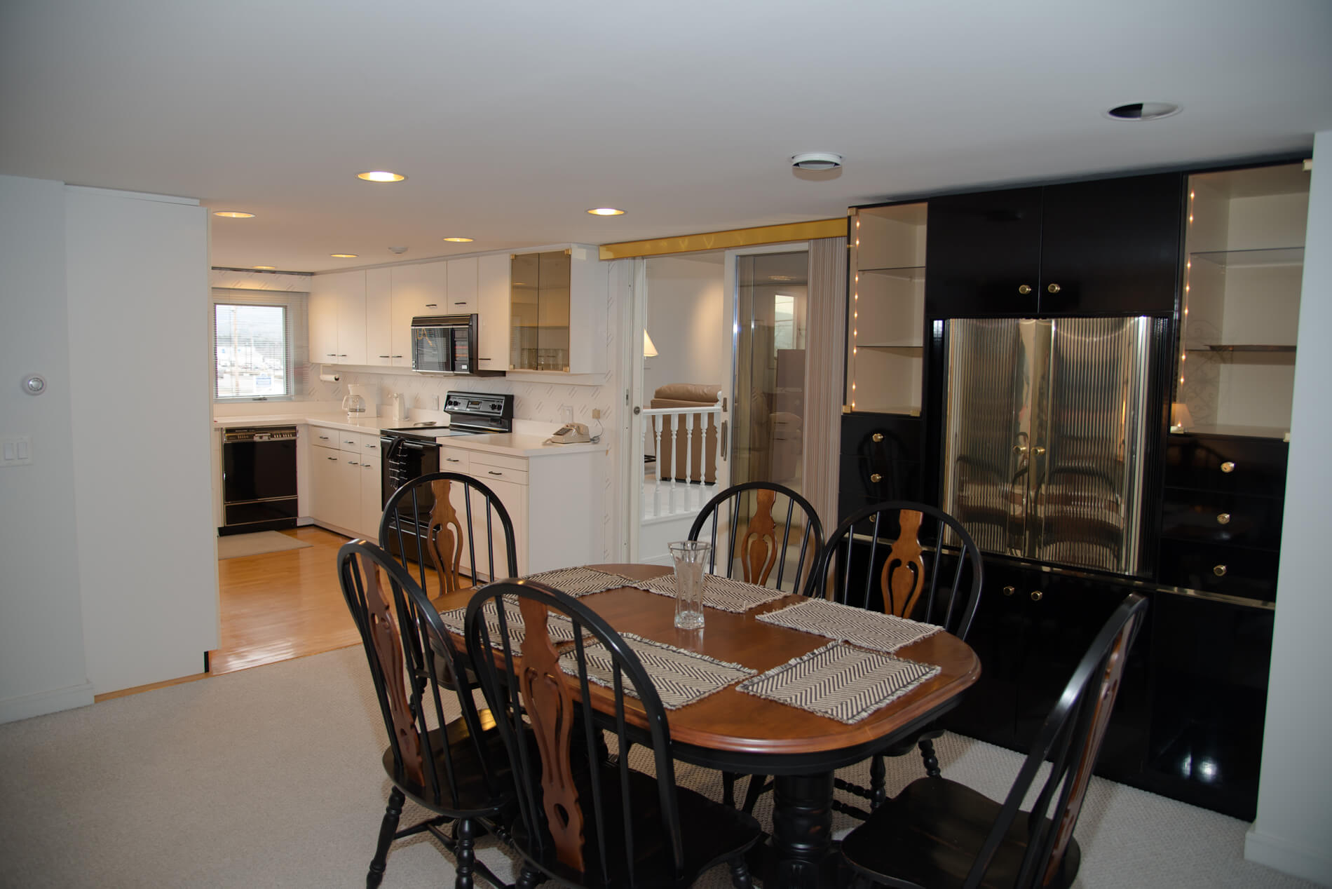 Spacious living room combo with kitchen. Dining room table is black and wood colored design.